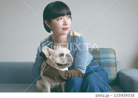 ソファでくつろぐ犬と若い女性 133939338