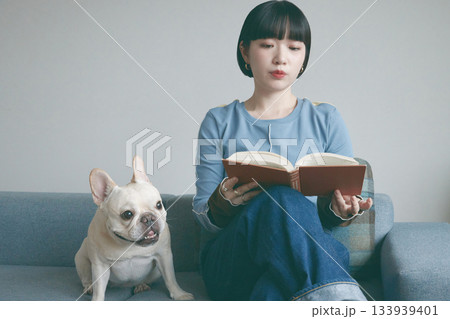 ソファで本を読む女性と犬 ソファで本を読む女性と犬 133939401
