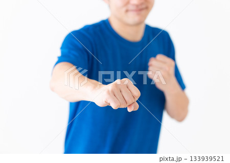 格闘技の構えをするTシャツ姿のミドル男性 格闘技の構えをするTシャツ姿のミドル男性 133939521