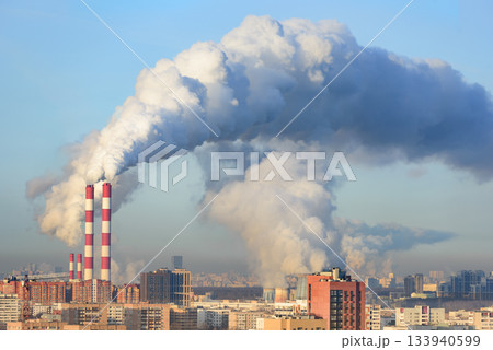 Fuming industrial tubes chimneys smoke heating station big city blue sky Fuming industrial tubes chimneys smoke heating station big city blue sky 133940599