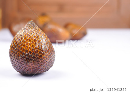 Fresh salak fruit or snake fruit with textured brown skin on white background 133941223