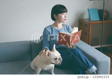 ソファでくつろぐ犬と若い女性 ソファでくつろぐ犬と若い女性 133942153