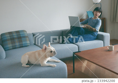 ソファでくつろぐ犬と若い女性 ソファでくつろぐ犬と若い女性 133942200