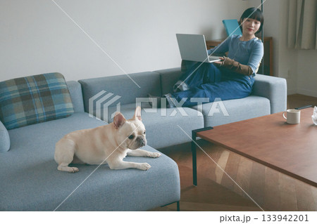 ソファでくつろぐ犬と若い女性 ソファでくつろぐ犬と若い女性 133942201
