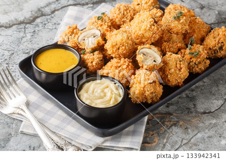 Crispy fried cremini mushrooms in panko breading close-up in a plate. Horizontal Crispy fried cremini mushrooms in panko breading close-up in a plate. Horizontal 133942341