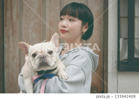犬を抱き抱える女性 133942409