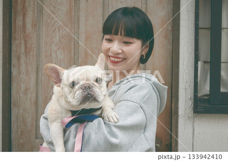 犬を抱き抱える女性 133942410