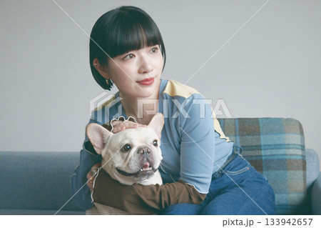 ソファでくつろぐ犬と若い女性 ソファでくつろぐ犬と若い女性 133942657