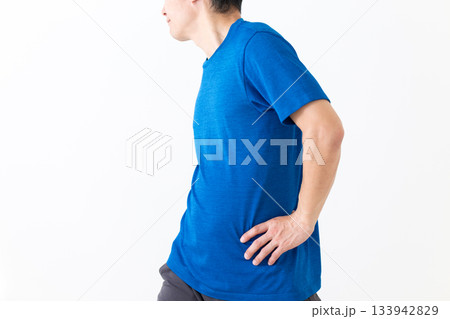 腰のストレッチ体操をするTシャツ姿のミドル男性 腰のストレッチ体操をするTシャツ姿のミドル男性 133942829
