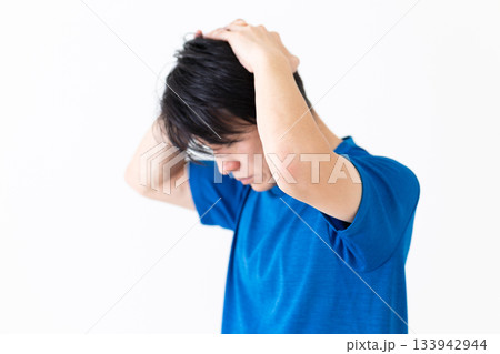 首のストレッチ体操をするTシャツ姿のミドル男性 133942944