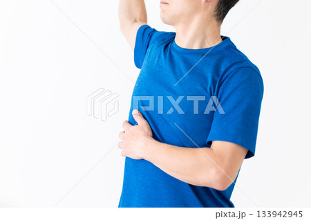 腰のストレッチ体操をするTシャツ姿のミドル男性 133942945