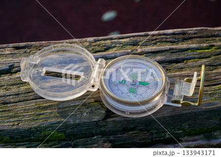 small travel  compass on textured wooden 133943171