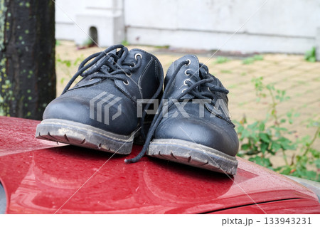 Outdoor. Pair of shoes on car capot Outdoor. Pair of shoes on car capot 133943231