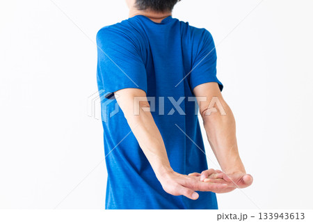 腕のストレッチ体操をするTシャツ姿のミドル男性 腕のストレッチ体操をするTシャツ姿のミドル男性 133943613