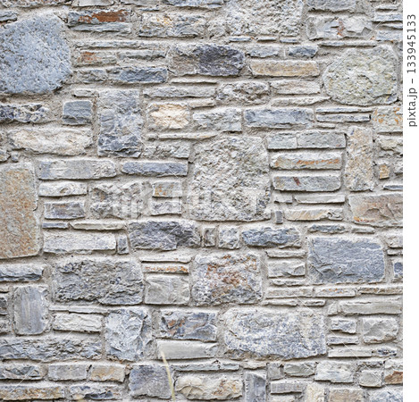 Rough stone wall texture with varied gray, beige, and blue stones for a rustic backdrop 133945133