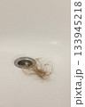 Water drain hole is clogged with long hair clump. Close-up.  133945218