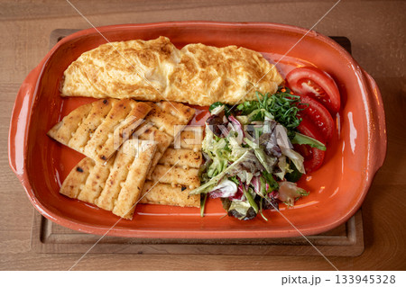 Delicious omelette served with fresh salad and crispy bread during brunch Delicious omelette served with fresh salad and crispy bread during brunch 133945328