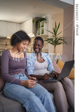 Mother and Daughter Using Laptop and Smartphone at Home 133945398
