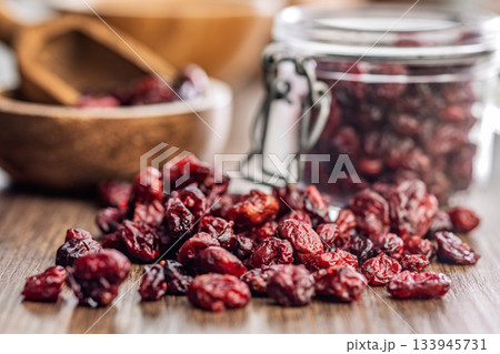 Tasty dried cranberries on wooden table. 133945731