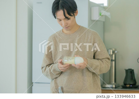 ミルクの温度を確認するパパ 133946633