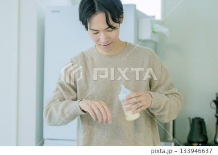 ミルクの温度を確認するパパ 133946637