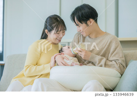 ソファーで赤ちゃんに授乳する家族 133946639