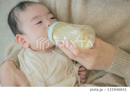 ソファーで赤ちゃんに授乳する家族 ソファーで赤ちゃんに授乳する家族 133946641