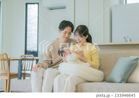 ソファーで赤ちゃんに授乳する家族 133946645