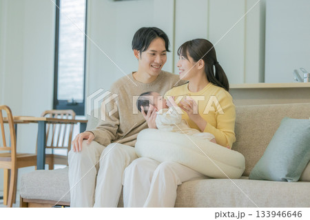 ソファーで赤ちゃんに授乳する家族 133946646