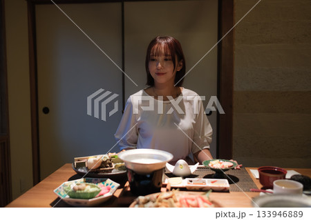 旅館の夕食時間｜くつろぐ女性と会席料理 133946889