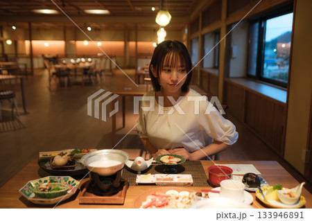 旅館の夕食時間｜くつろぐ女性と会席料理 133946891
