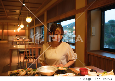 旅館の夕食時間｜くつろぐ女性と会席料理 133946893