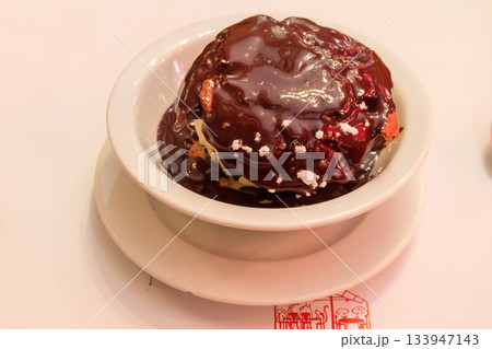 Profiterole with ice cream and chocolate sauce on a table in restaurant Profiterole with ice cream and chocolate sauce on a table in restaurant 133947143