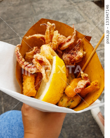 Typical Italian appetizer (Fritto misto di pesce) mix of fried seafood i female hand. Healthy snack in Genoa, Cinque Terre and Portofino Typical Italian appetizer (Fritto misto di pesce) mix of fried seafood i female hand. Healthy snack in Genoa, Cinque Terre and Portofino 133947146