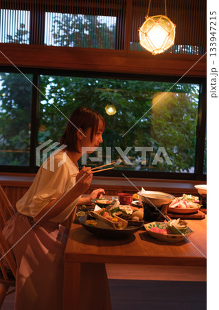 旅館の夕食時間｜窓辺でくつろぐ食事風景 133947215