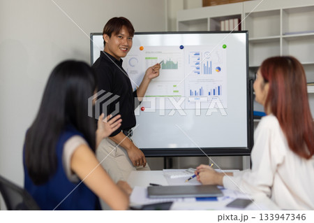 Asian businessman leading meeting with presentation on whiteboard. 133947346