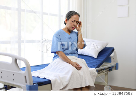 Senior patient suffering from severe headache in hospital room. 133947598