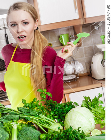 Woman having green vegetables thinking about cooking Woman having green vegetables thinking about cooking 133947790