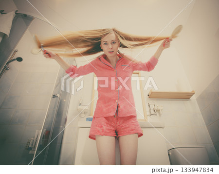 Woman brushing her long hair Woman brushing her long hair 133947834