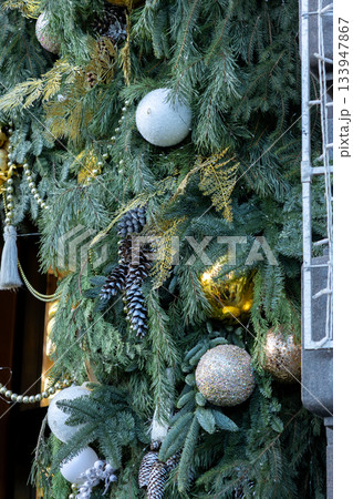 Christmas tree with many ornaments and pine cones. 133947867