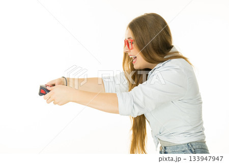 Profile view of woman playing video games 133947947