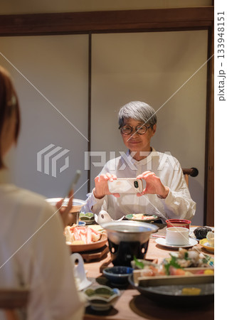 和食レストランで親子が食事を楽しみながら写真を撮るシーン 133948151