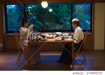 和食レストランで親子が食事を楽しみながら写真を撮るシーン 和食レストランで親子が食事を楽しみながら写真を撮るシーン 133948155