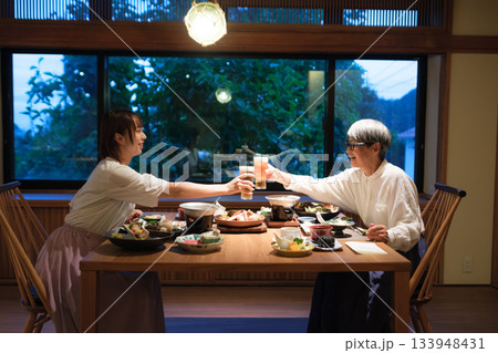 旅館の夕食で親子が乾杯を交わす温かい団らんのひととき 旅館の夕食で親子が乾杯を交わす温かい団らんのひととき 133948431