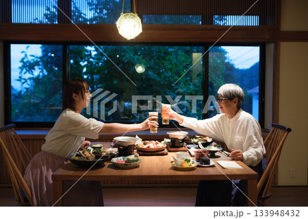 旅館の夕食で親子が乾杯を交わす温かい団らんのひととき 133948432