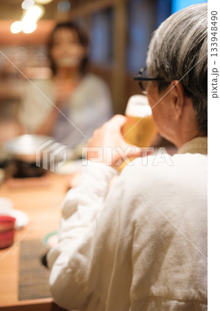 旅館の夕食で親子がビールを楽しむ穏やかなひととき 旅館の夕食で親子がビールを楽しむ穏やかなひととき 133948490