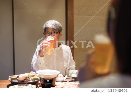 旅館の夕食で親子がビールを楽しむ穏やかなひととき 133948491