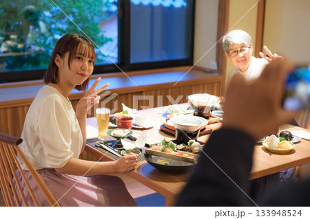 旅館の夕食で親子三人が撮り合いながら楽しむ思い出づくりの時間 旅館の夕食で親子三人が撮り合いながら楽しむ思い出づくりの時間 133948524