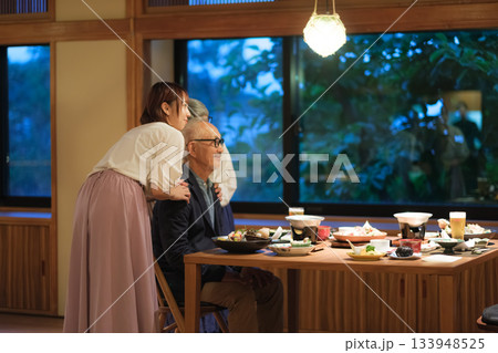 旅館の夕食で親子三人が撮り合いながら楽しむ思い出づくりの時間 133948525