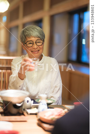 旅館の夕食でシニア夫婦がお酌を交わす温かいひととき 旅館の夕食でシニア夫婦がお酌を交わす温かいひととき 133948601
